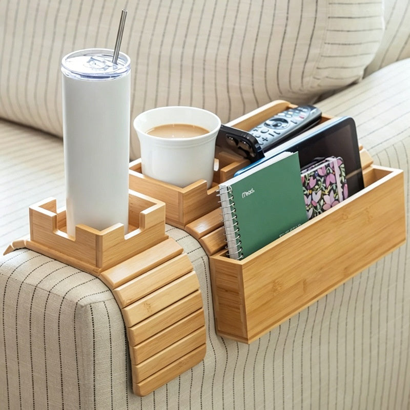 Bamboo couch-arm tray with cup holder and phone slot holding drinks, remote, phone and notebook